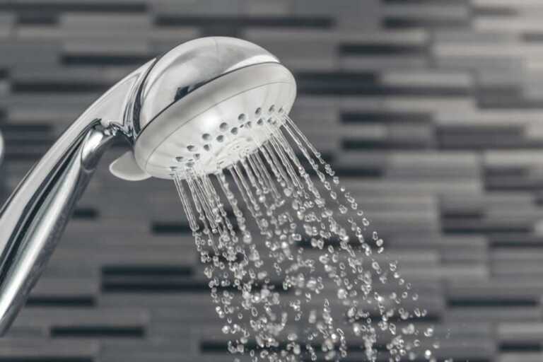 water pouring from round handheld shower head