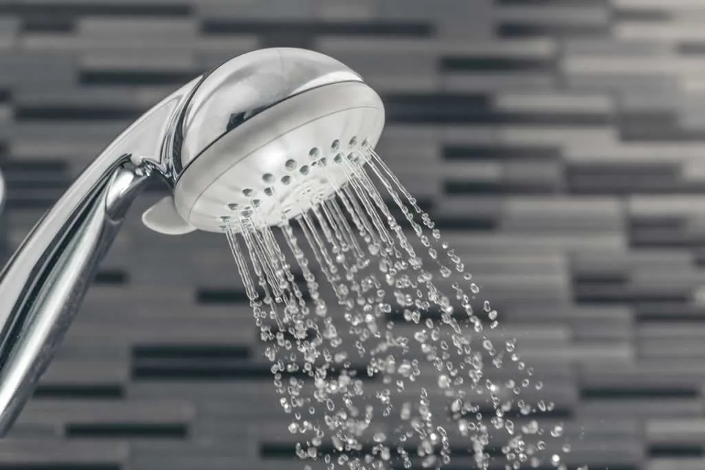 water pouring from round handheld shower head