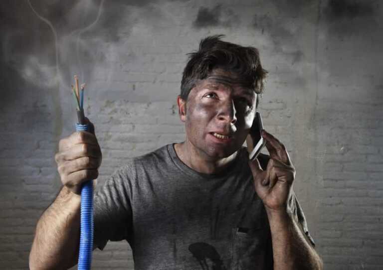 burned man holding electric cable