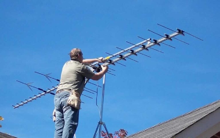 man installing TV antenna on the roof