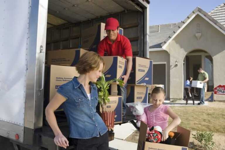 family unloading moving boxes from the truck