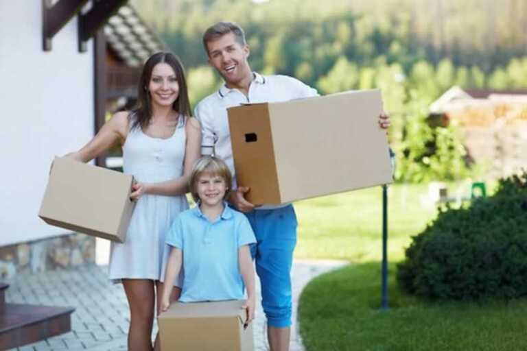 family carrying moving boxes
