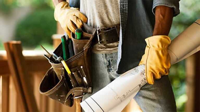 handyman with tool belt and renovation plans