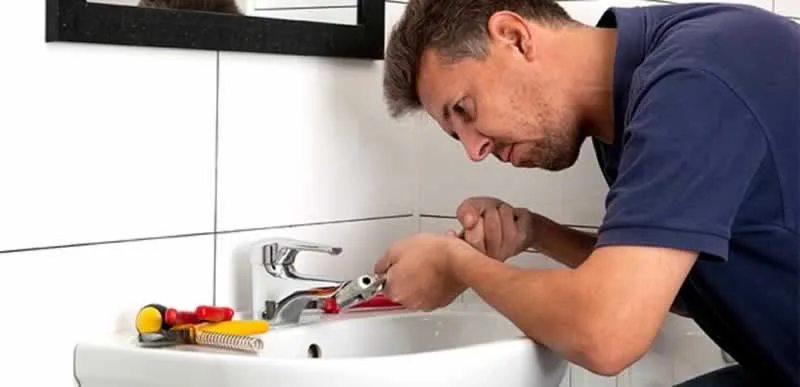 man fixing leaky tap