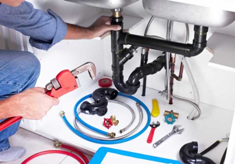plumber removing the drain pipe under the sink