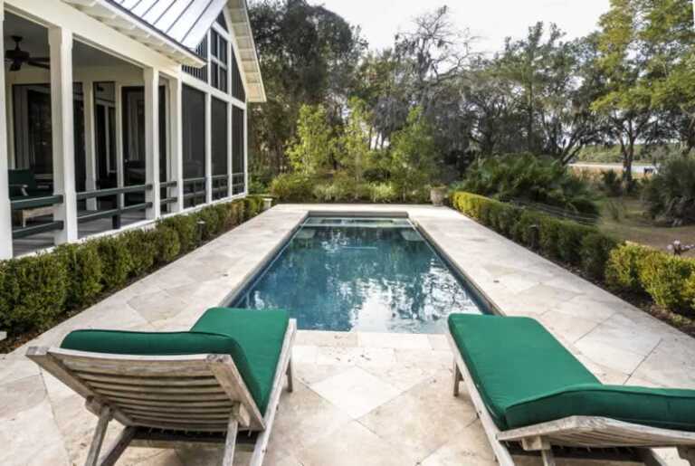 small swimming pool with concrete patio in the backyard
