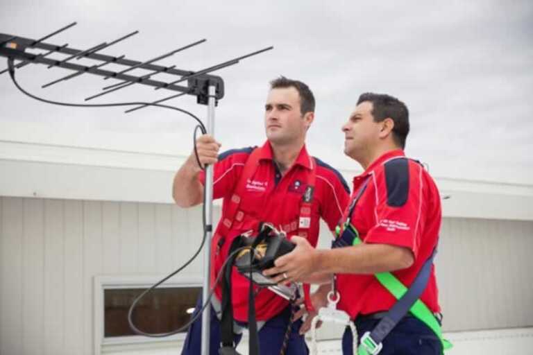technicians checking the signal on TV antenna