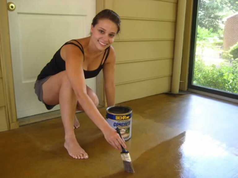 woman staining old concrete
