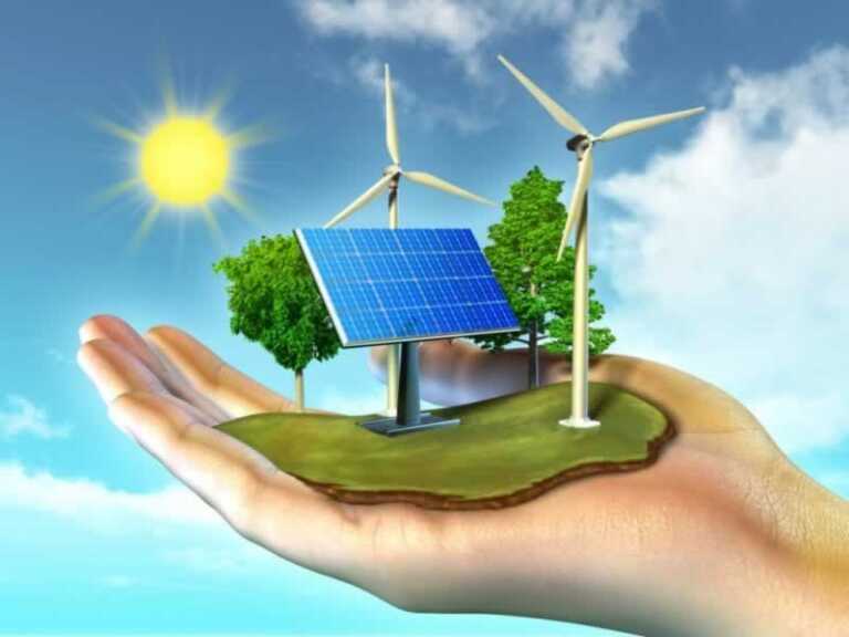 trees, solar panels and wind power plants on the palm of the hand