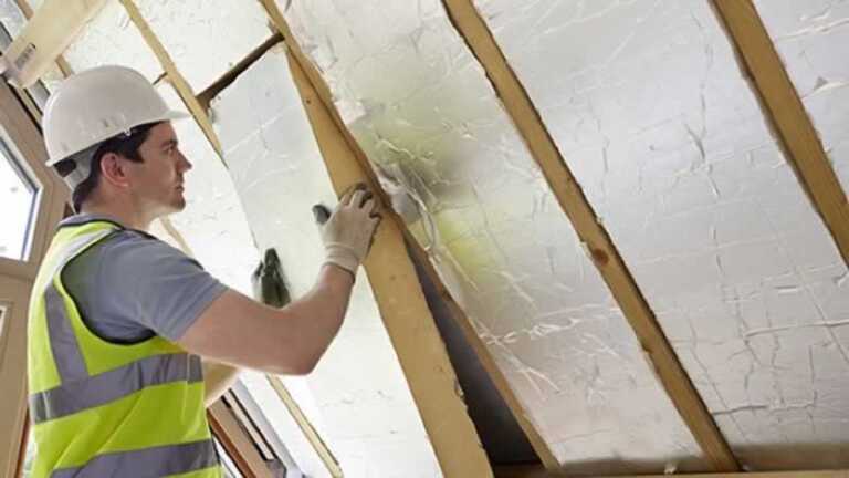 man installing insulation in the attic