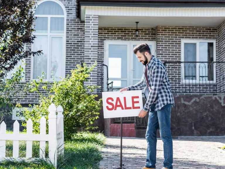 posting sale sign in front of the house