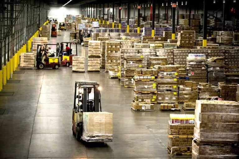 forklifts carrying packages in a huge warehouse