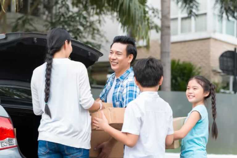 family putting moving boxes into the car