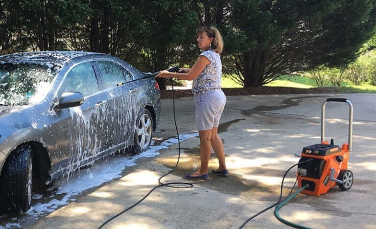 Women washing car withe pressure washer