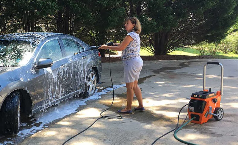 Women washing car withe pressure washer