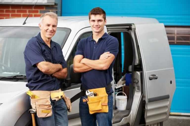 Two plumbers with company car