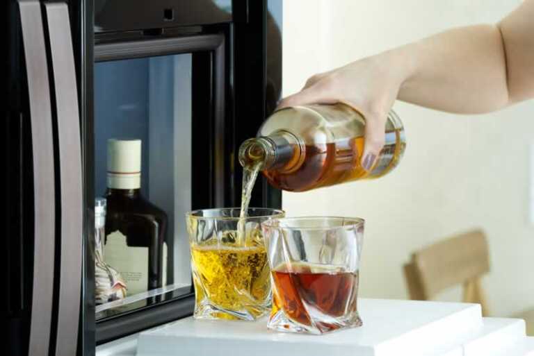 pouring whiskey from the fridge