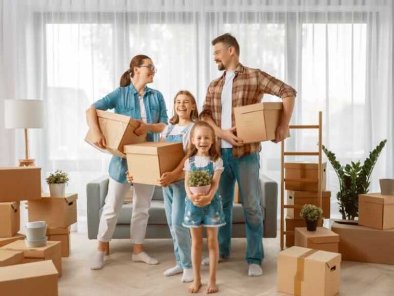 family carrying moving boxes