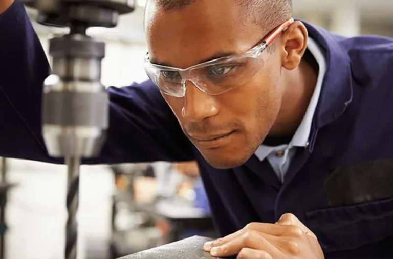 man drilling with safety glasses