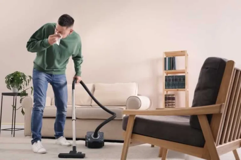 man with allergy vacuuming