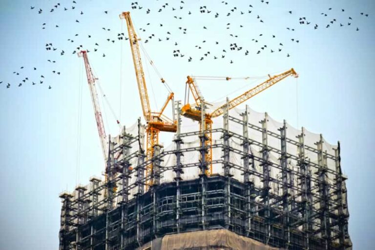 skyscraper construction with cranes on the top