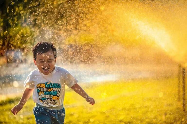 kid under the sprinklers