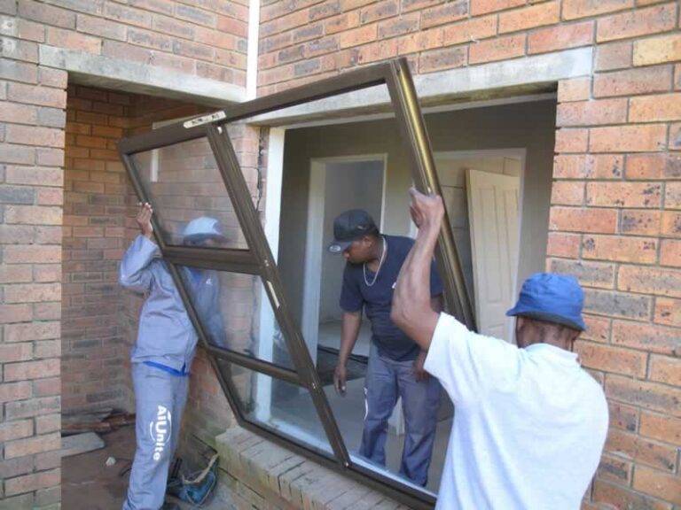 workers installing aluminum window in family home