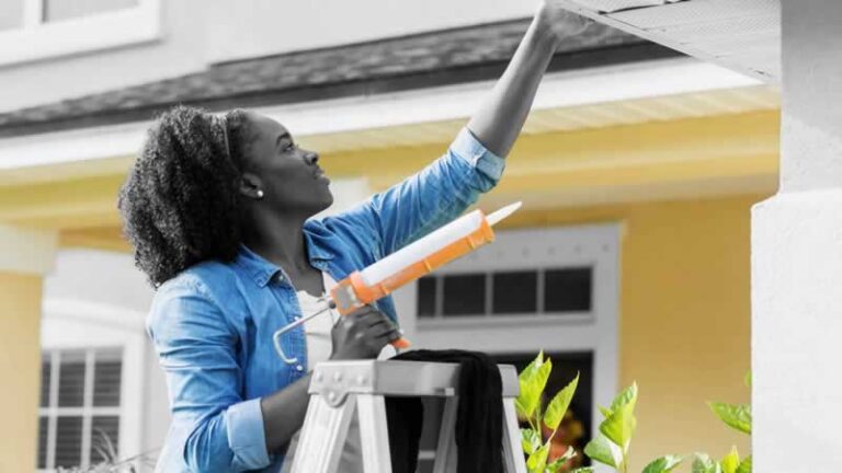woman caulking the house