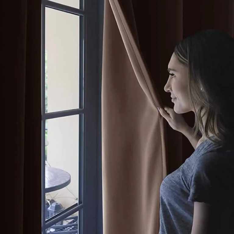 woman opening blackout curtains in the morning