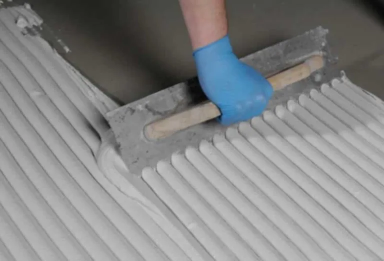 putting tile adhesive on the floor