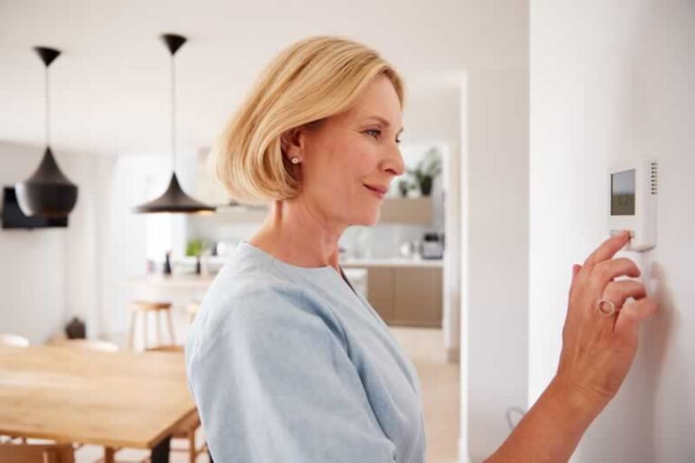 woman checking thermostat