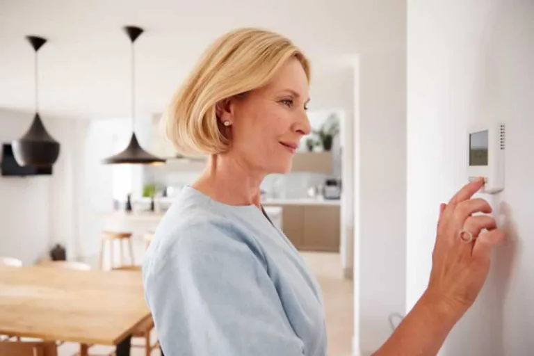 woman checking thermostat