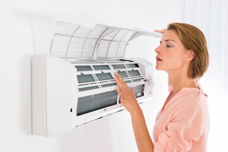 woman checking indoor AC unit