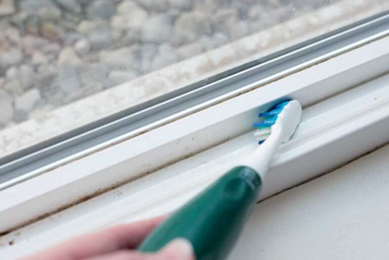cleaning windowsill with toothbrush