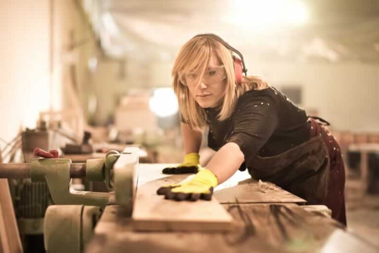 female woodworker planing wood