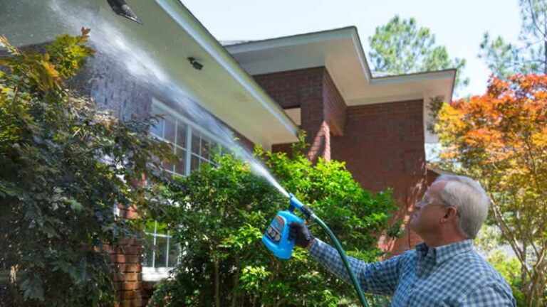 man cleaning home's exterior