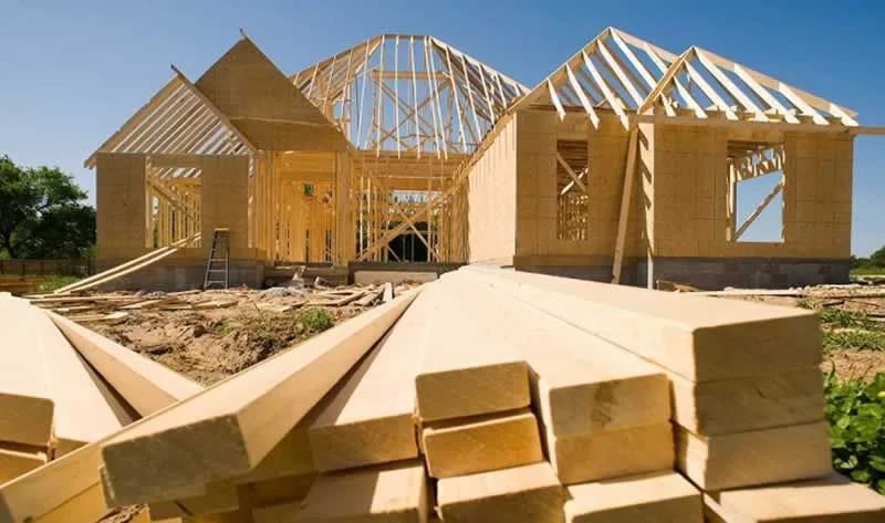pile of lumber in front of house in construction