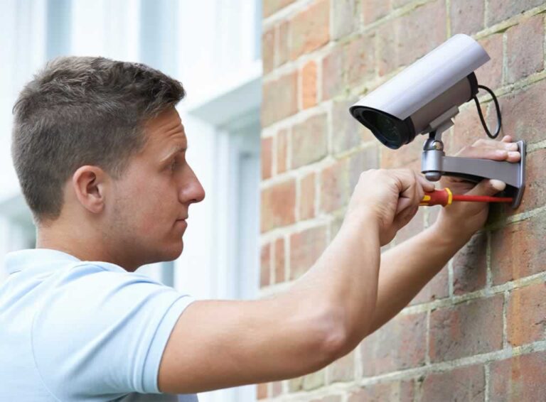 man installing CCTV camera at home