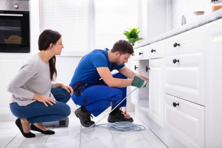 plumber cleaning drain under the sink