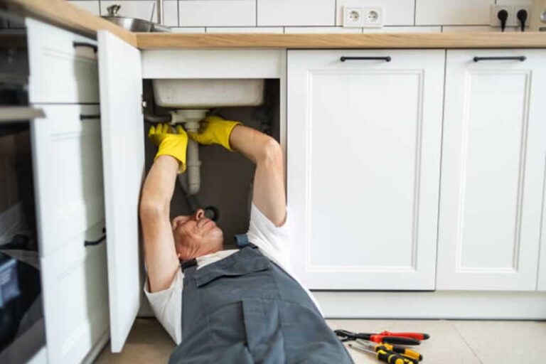 plumber repairing sink drain