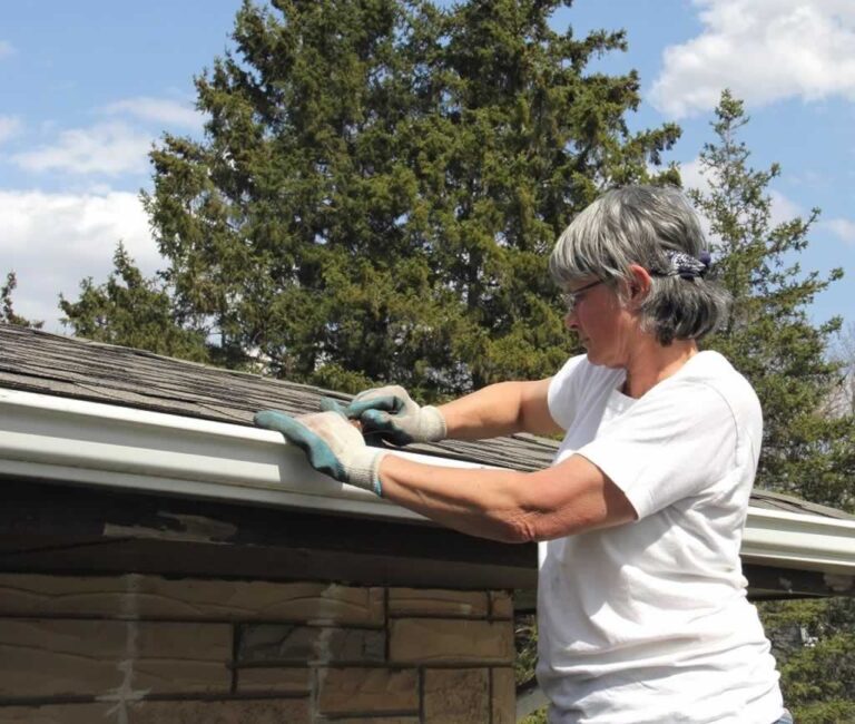 woman cleaning the gutters