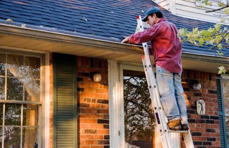 man cleaning gutters from ladders