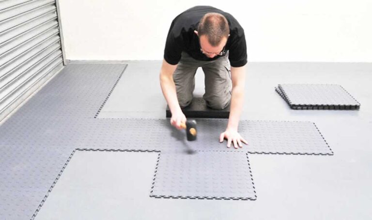 man setting up interlocking floor in the garage