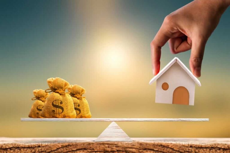 putting a model house on scale with bags of money