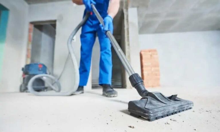 worker vacuuming builders' dust after renovation