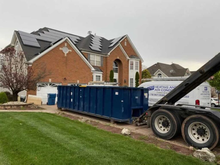 unloading the dumpster from the truck on the driveway