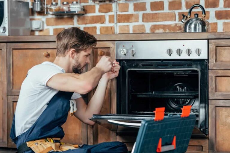 appliance repair professional repairing oven