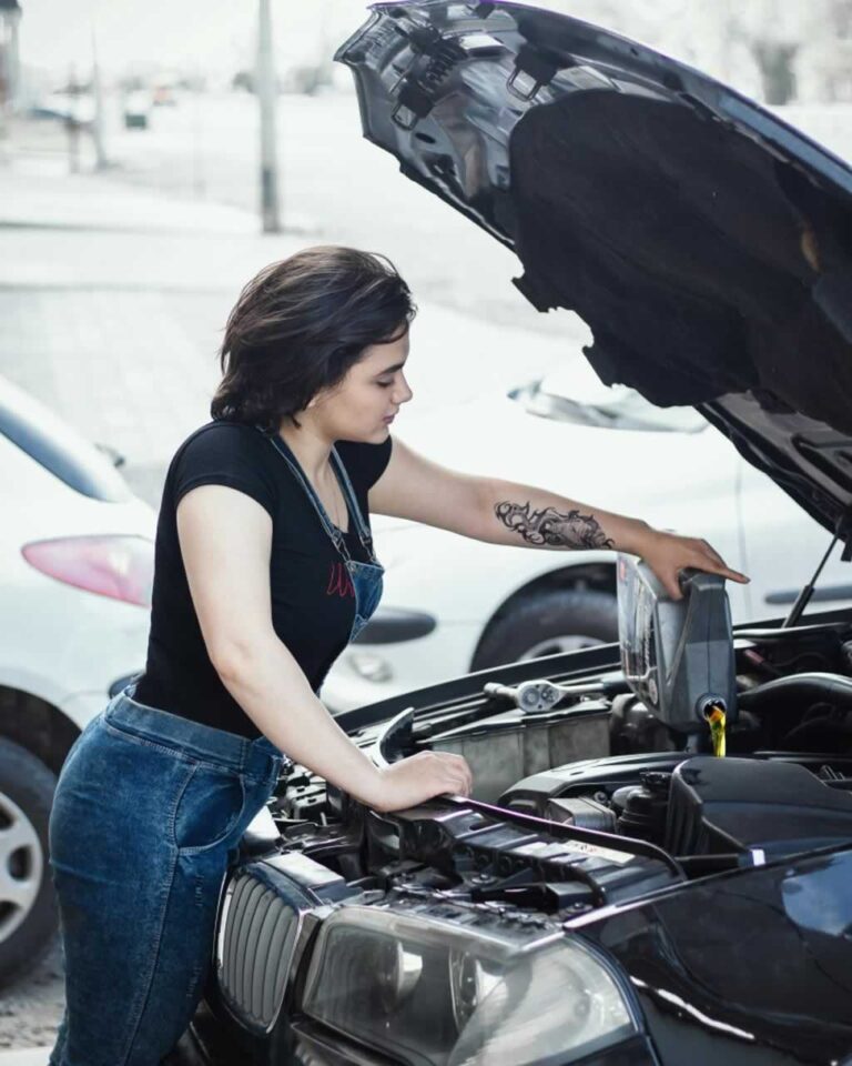 woman pouring oil in the car