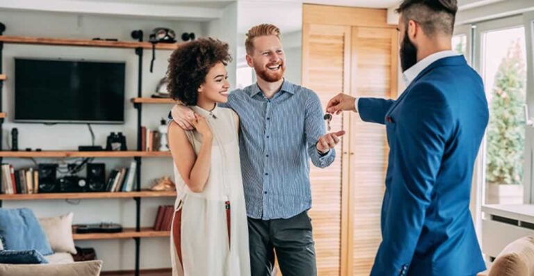 couple receiving house keys from real estate agent