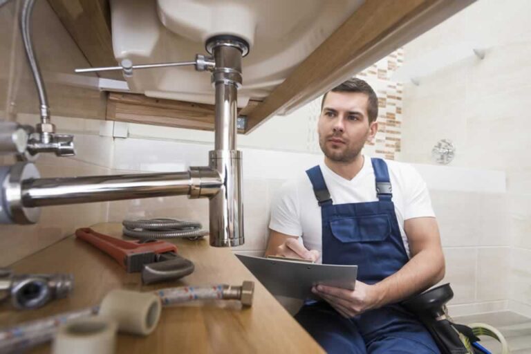 reliable plumber assessing the condition of the pipes